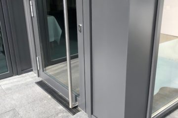 Graue Stahltür mit Glaseinsatz